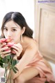 A woman in a pink dress holding a bunch of flowers.